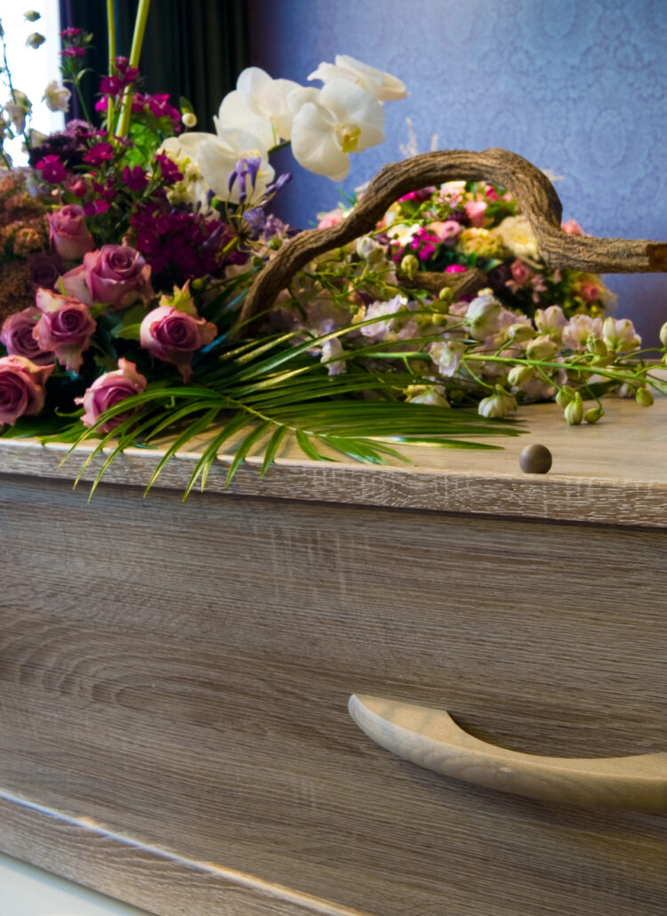 casket at memorial service with flowers and candle