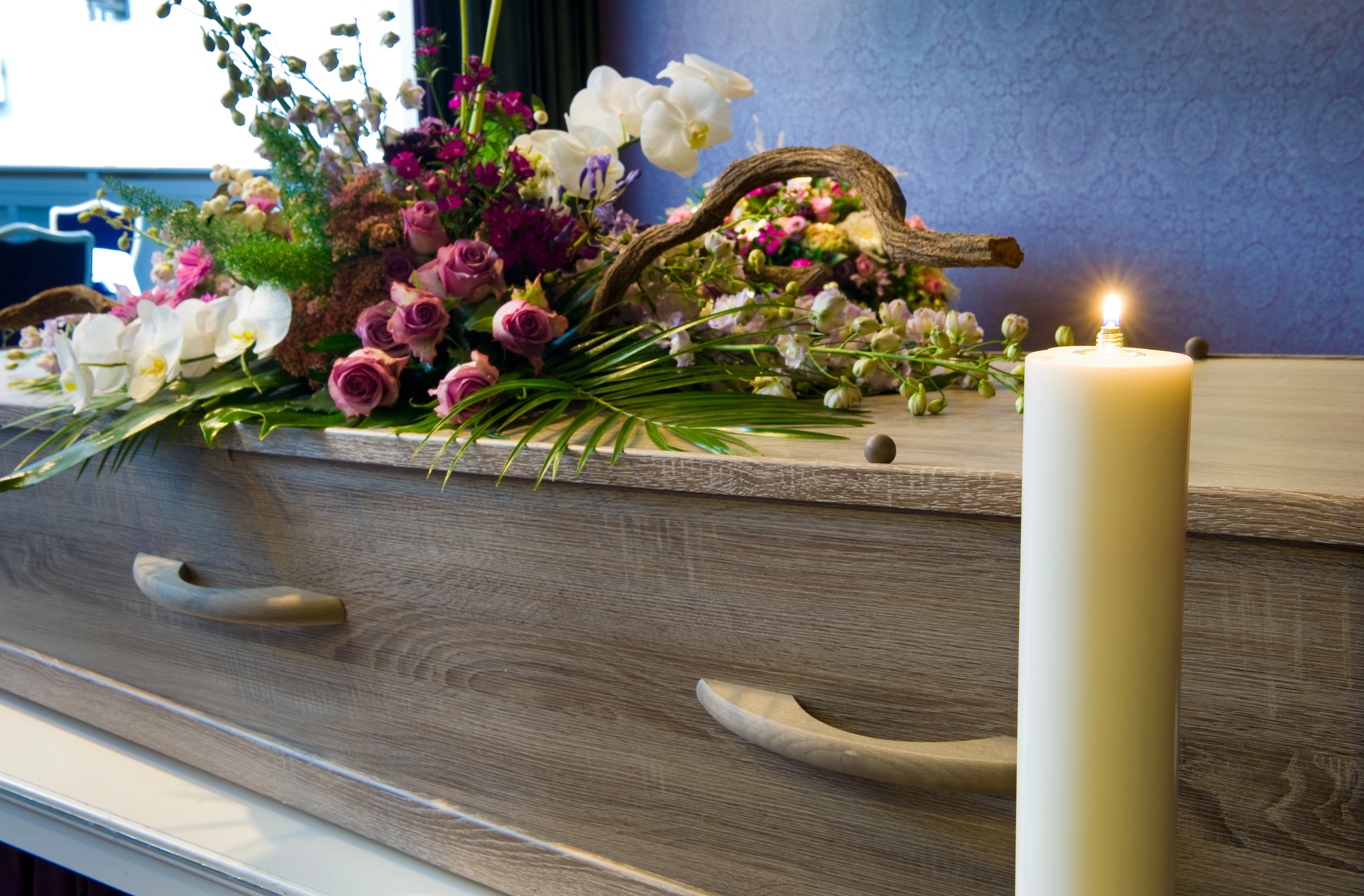 casket at memorial service with flowers and candle